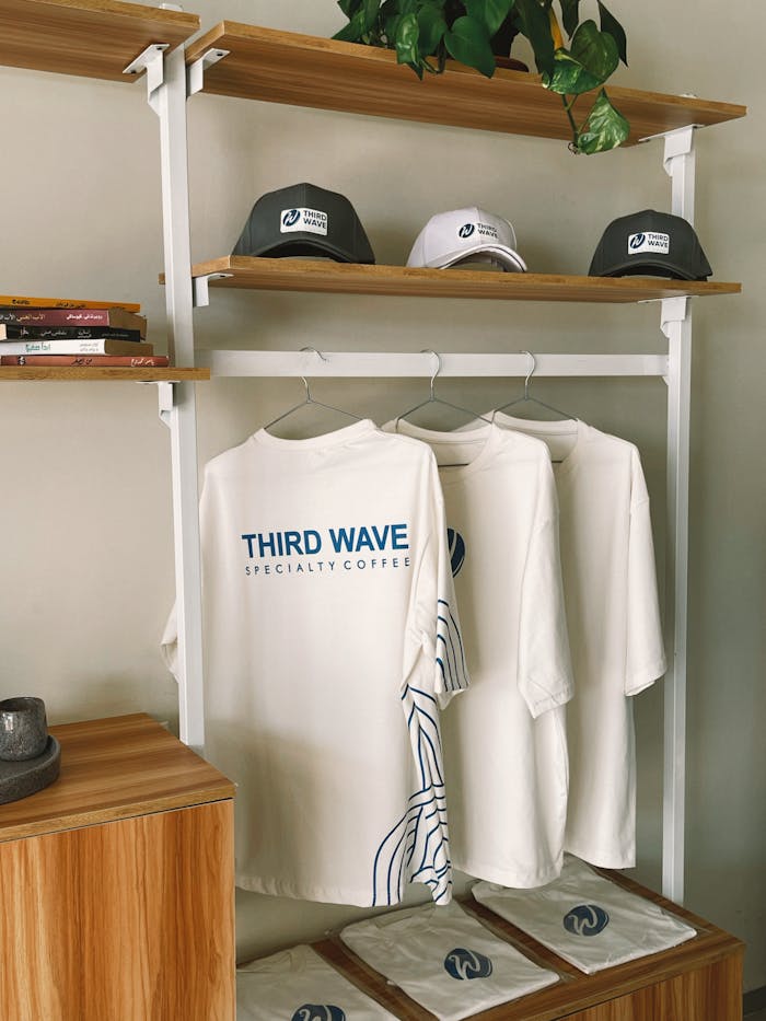 Stylish display of cafe-themed T-shirts and caps in a trendy setting.